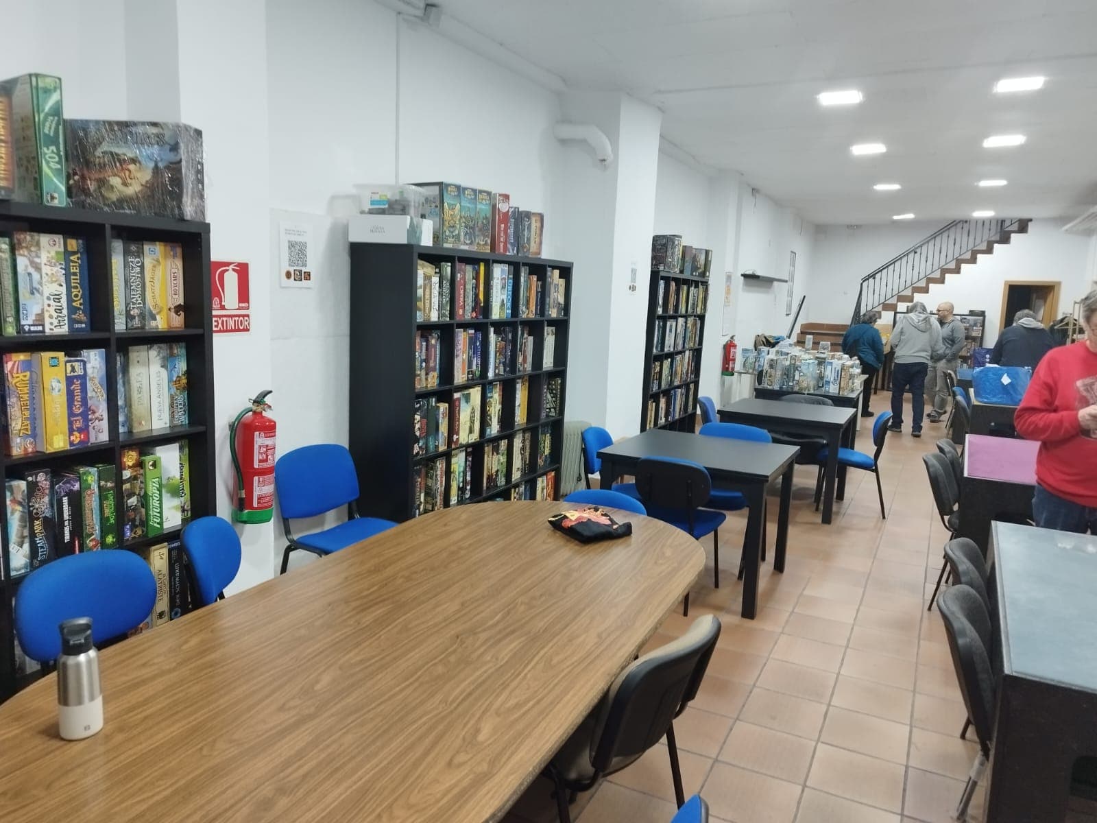 Interior del Club Da2 con socios jugando alrededor de las mesas