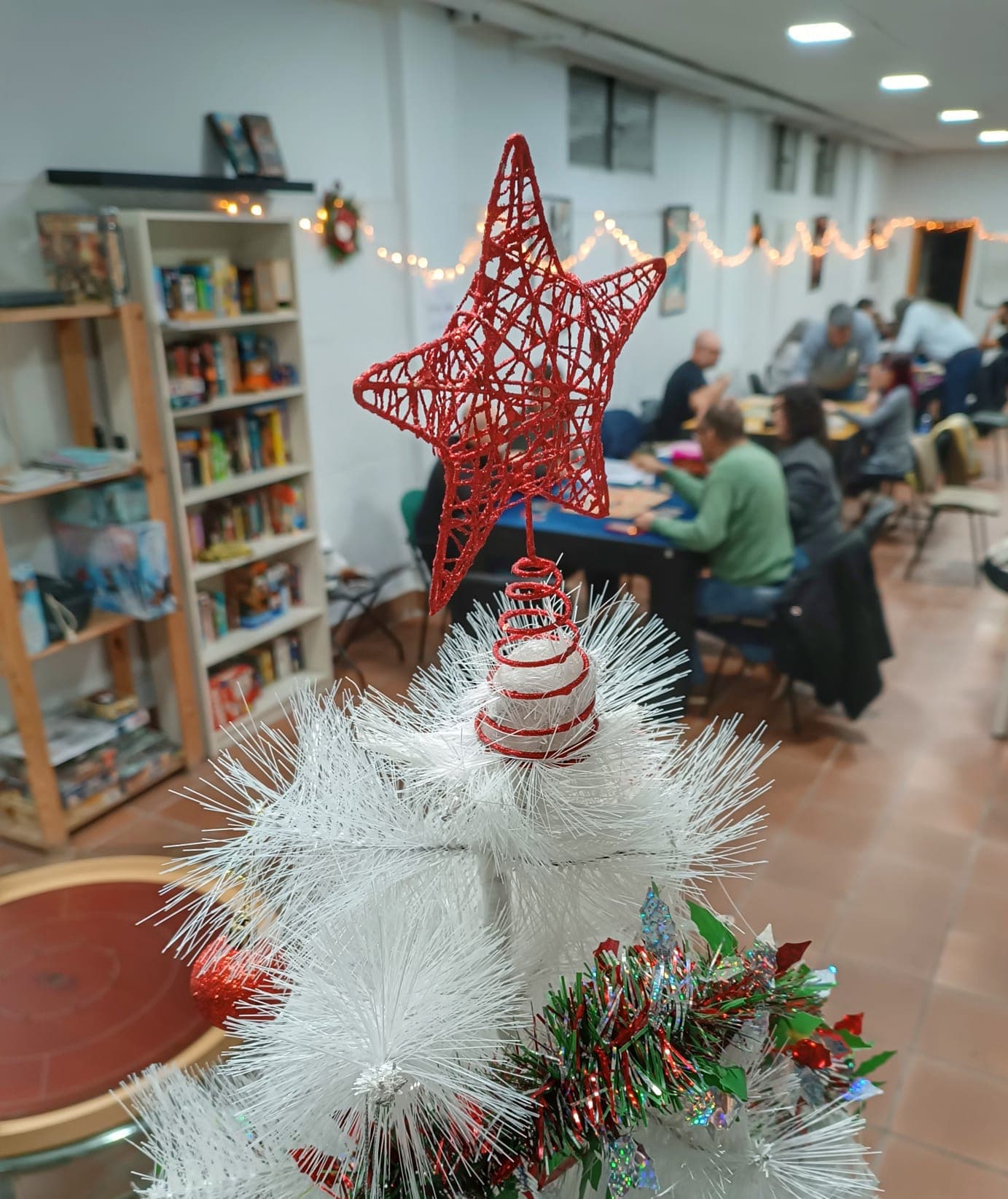 Ambiente navideño en el club con socios jugando al fondo